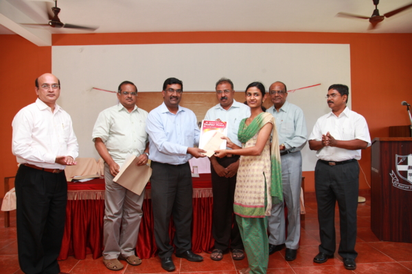 Dr. Georgie Kurien Muthoot felicitating a student with the Muthoot M George Memorial Research Award